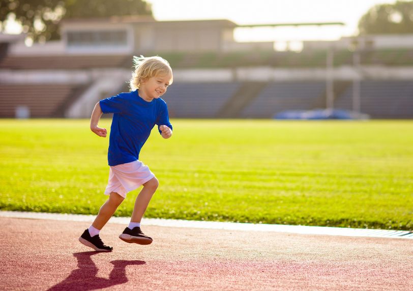 child running on a race track, extremely happy.